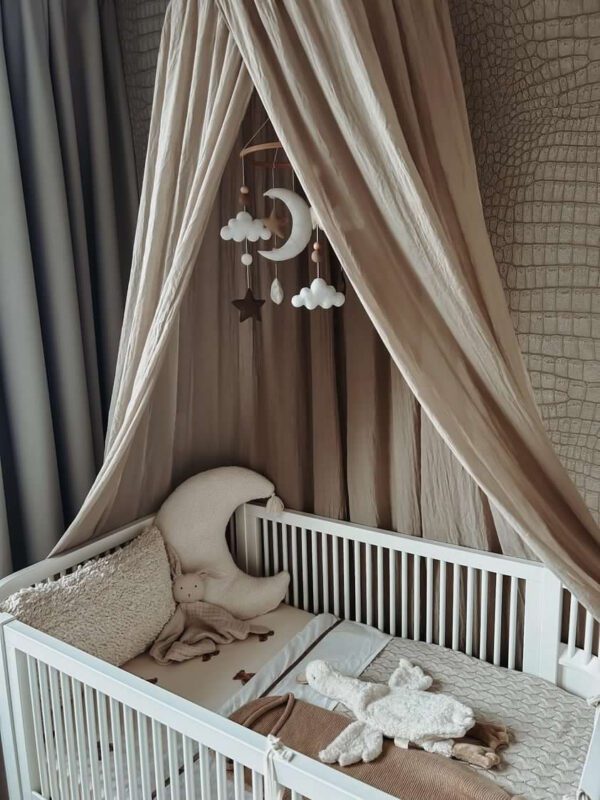 In the clouds met neutrale kleuren babykamer met mobiel met maan en sterren